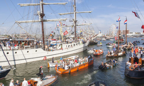 Schepen varen langs de Stad Amsterdam